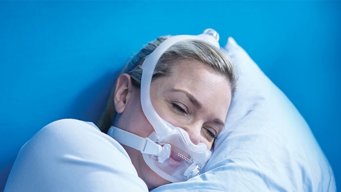 woman sleeping with cpap mask on bed tricare medical