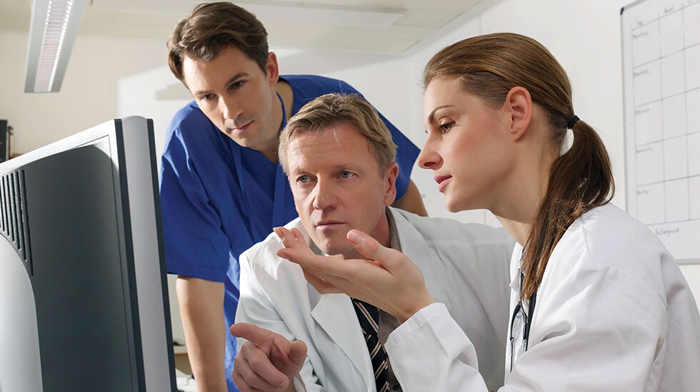 Download image (.jpg) (opens in a new window) Two doctors reviewing mammogram case