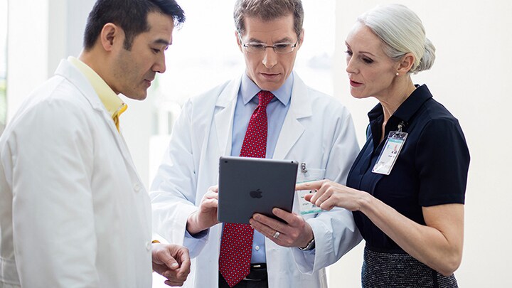 Healthcare administrators discussing data on a tablet