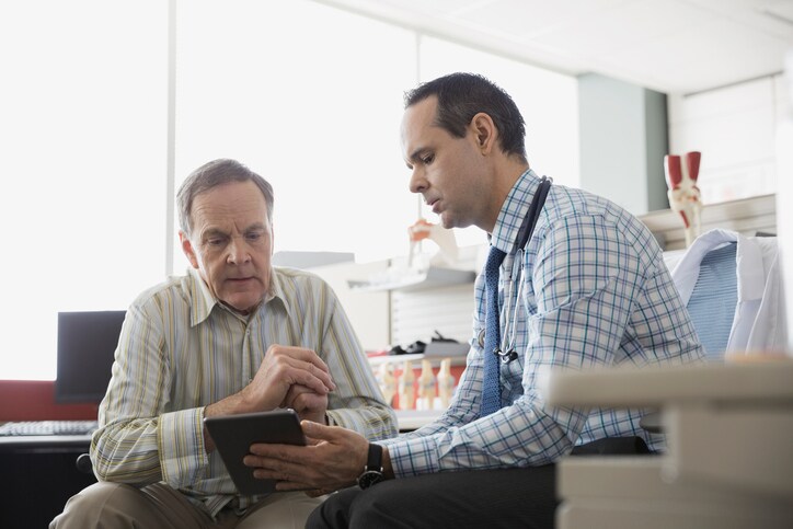Doctor and senior patient using digital tablet