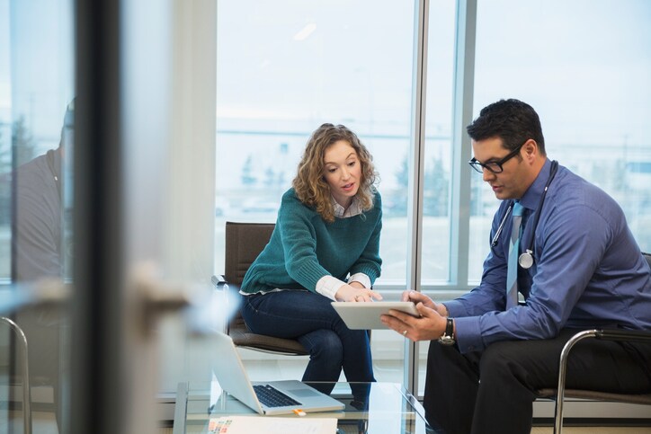 Doctor and patient in consultation with digital tablet