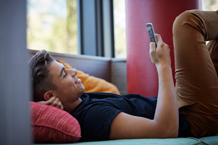 Young man relaxing and looking at phone