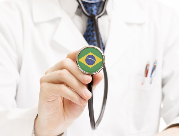 Doctor holding end of stethoscope with a Brazilian flag on|Doctor holding end of stethoscope with a Brazilian flag on