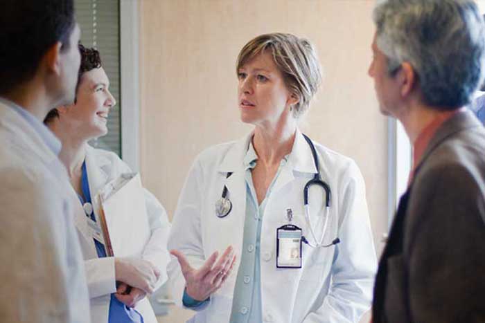 A female doctor is explaining something to a group of healthcare professionals