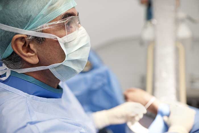 Close-up profile of a surgeon working, in the middle of a procedure 