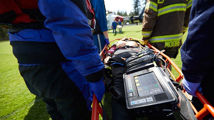 Download image (.jpg) A simulated scenario of a HEMS medical team transferring a patient from scene to a helicopter with continuous monitoring (opens in a new window)