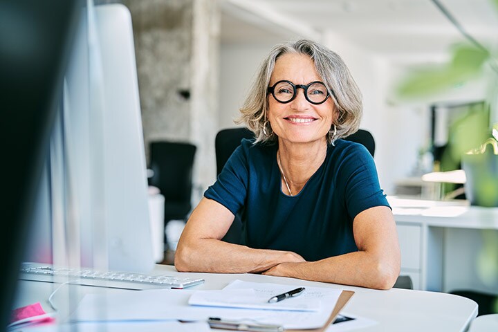 Woman smiling behind her desk