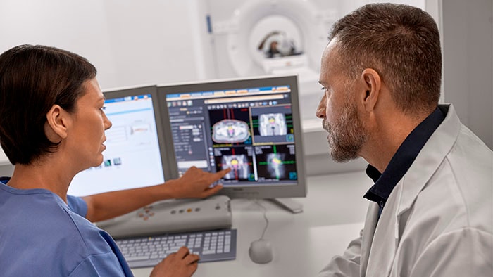 Philips CT scanner operated by doctor and tech support in the control room -  