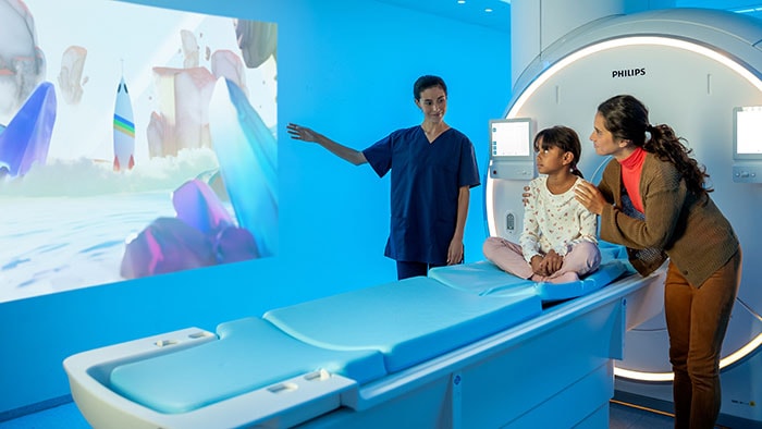 Download image (.jpg) (opens in a new window) A nurse reassuring a child and mother before the MRI exam by means of Pediatric Coaching.