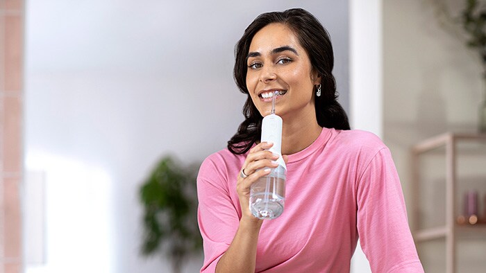 Woman using Philips Sonicare Power Flosser