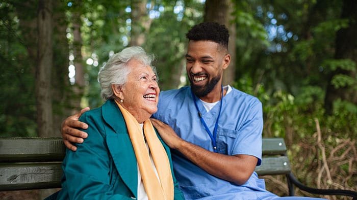 A healthcare professional and patient on a bench -  